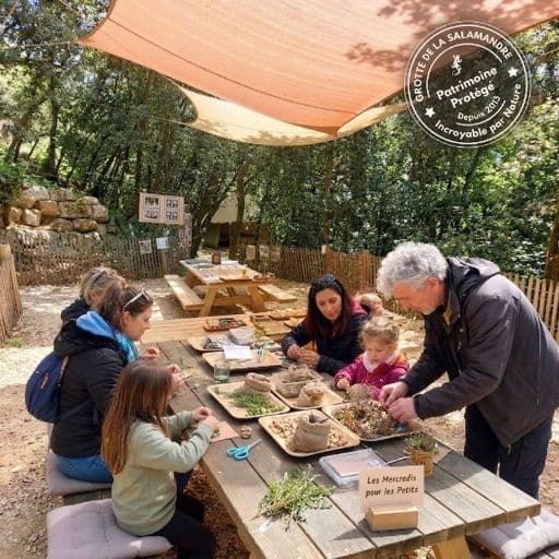 Un groupe d'adulte et d'enfants en train de faire un atelier créatif sur l'air de picnic
